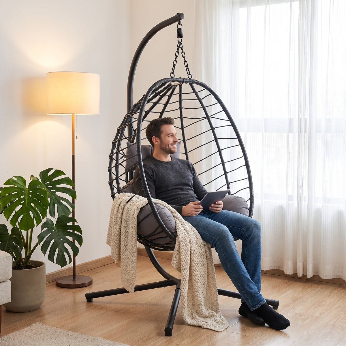 Silla colgante en sala con un hombre sentado